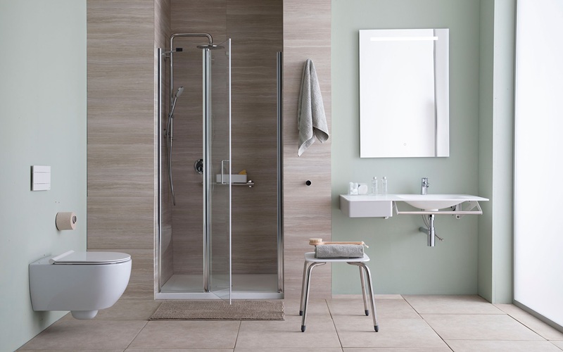 Bagno accessibile con doccia a filo pavimento, box in vetro, rivestimento effetto legno, lavabo sospeso e sgabello bianco